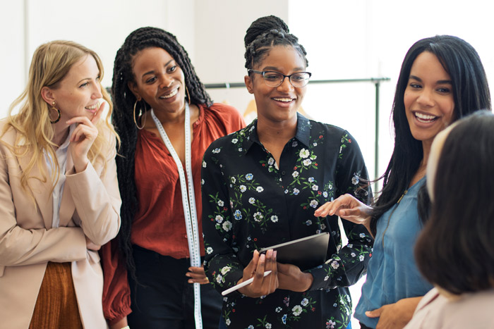 happy-diverse-businesswoman-using-digital-tablet-web diverse group of women talking